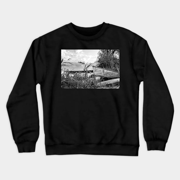 Old canoes and kayaks on the river bank in Thurne, Norfolk Crewneck Sweatshirt by yackers1